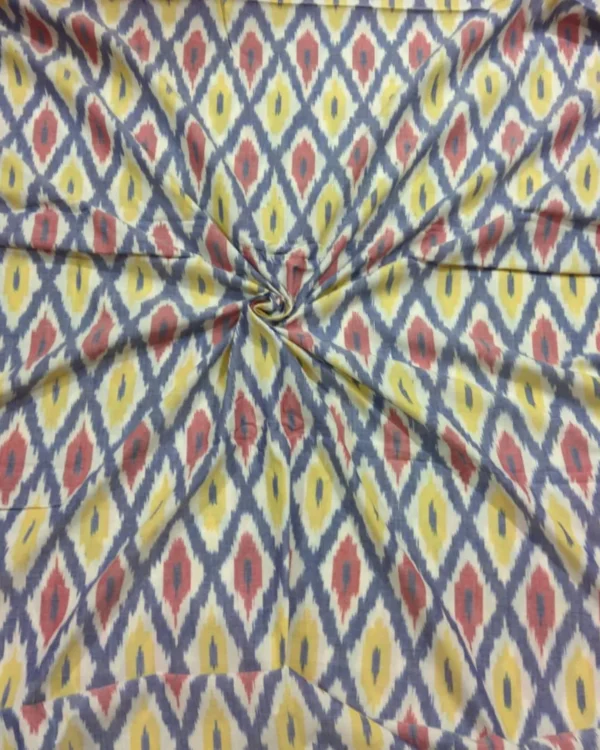 Colorful ikat pattern woven fabric in shades of red, yellow, and blue, spread out and twisted in the center to showcase the intricate design, 45-inch width, from PAVANKUMARWEAVES."