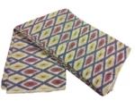 Colorful ikat pattern woven fabric in shades of red, yellow, and blue, spread out and twisted in the center to showcase the intricate design, 45-inch width, from PAVANKUMARWEAVES."