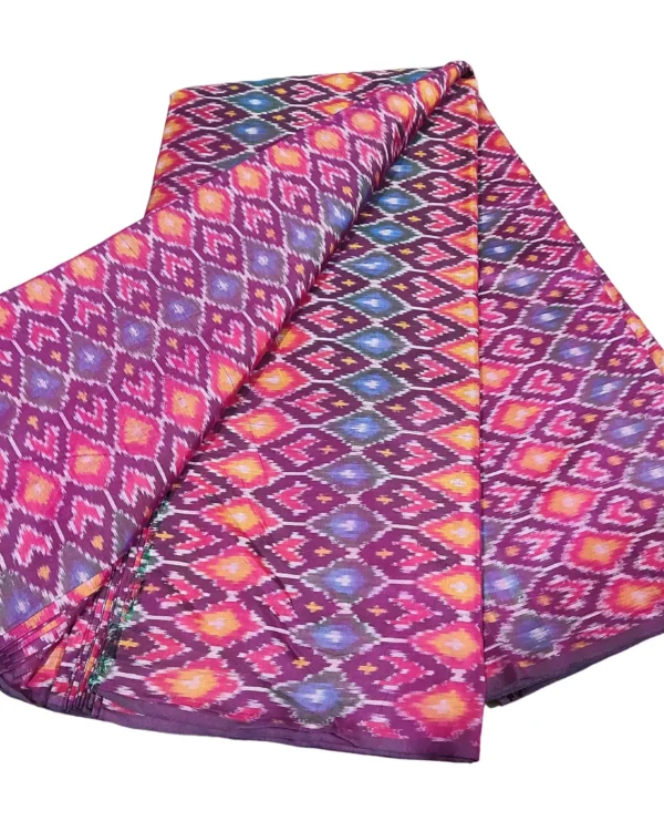 cotton silk fabric with a traditional ikat pattern featuring multicolored diamond motifs arranged in a symmetrical design."