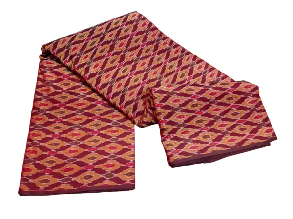 cotton silk fabric with a traditional ikat pattern featuring multicolored diamond motifs arranged in a symmetrical design."