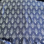 Blue and white ikat fabric featuring intricate diamond motifs, perfect for home decor or apparel