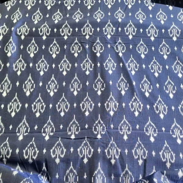 Blue and white ikat fabric featuring intricate diamond motifs, perfect for home decor or apparel