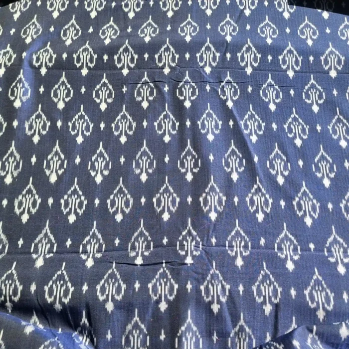 Blue and white ikat fabric featuring intricate diamond motifs, perfect for home decor or apparel
