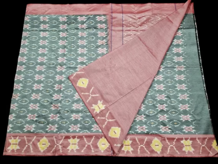 Photo of a handwoven semi-silk Pochampally saree featuring vibrant ikat diamond and temple motifs, showing the broad patterned border and pallu alongside a matching blouse piece.