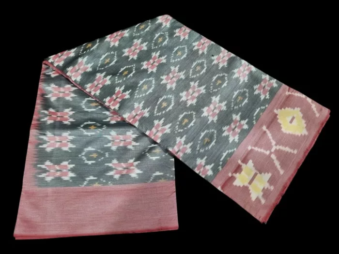 Photo of a handwoven semi-silk Pochampally saree featuring vibrant ikat diamond and temple motifs, showing the broad patterned border and pallu alongside a matching blouse piece.