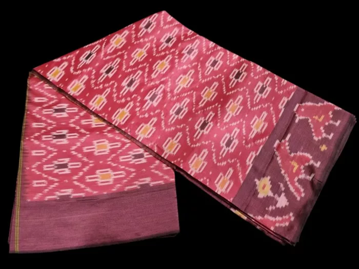 Close-up of a handwoven semi-silk Pochampally saree showing vibrant ikat diamond and temple motifs on a broad border