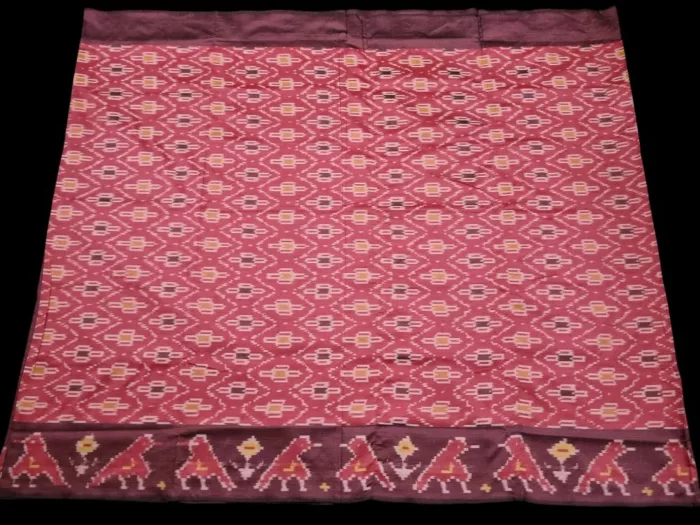 Close-up of a handwoven semi-silk Pochampally saree showing vibrant ikat diamond and temple motifs on a broad border