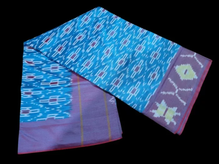Close-up of a handwoven semi-silk Pochampally saree showing vibrant ikat diamond and temple motifs on a broad border