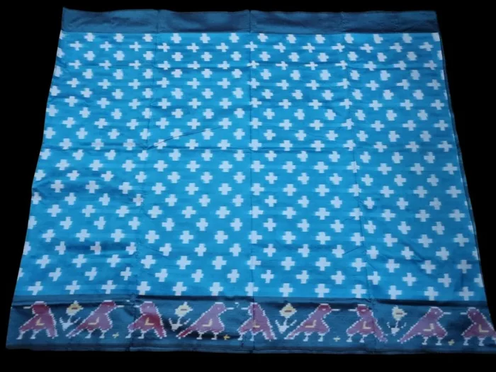 Close-up of a handwoven semi-silk Pochampally saree showing vibrant ikat diamond and temple motifs on a broad border