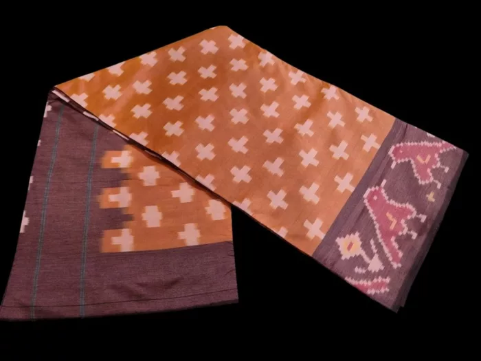 Close-up of a handwoven semi-silk Pochampally saree showing vibrant ikat diamond and temple motifs on a broad border