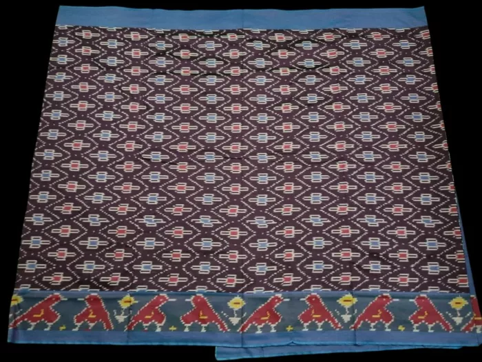Close-up of a handwoven semi-silk Pochampally saree showing vibrant ikat diamond and temple motifs on a broad border
