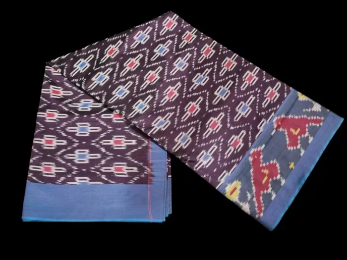 Close-up of a handwoven semi-silk Pochampally saree showing vibrant ikat diamond and temple motifs on a broad border