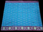 Close-up of a handwoven semi-silk Pochampally saree showing vibrant ikat diamond and temple motifs on a broad border