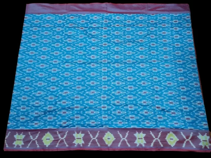 Close-up of a handwoven semi-silk Pochampally saree showing vibrant ikat diamond and temple motifs on a broad border