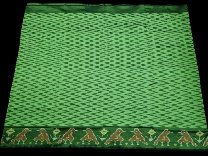 Close-up of a handwoven semi-silk Pochampally saree showing vibrant ikat diamond and temple motifs on a broad border