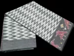 Close-up of a handwoven semi-silk Pochampally saree showing vibrant ikat diamond and temple motifs on a broad border