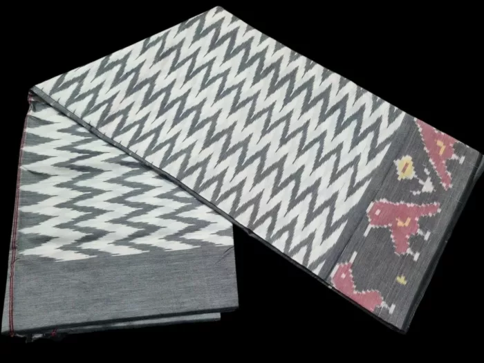 Close-up of a handwoven semi-silk Pochampally saree showing vibrant ikat diamond and temple motifs on a broad border