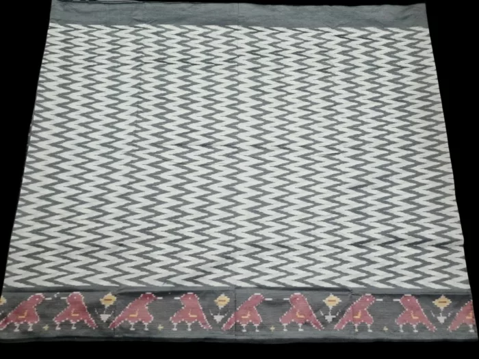 Close-up of a handwoven semi-silk Pochampally saree showing vibrant ikat diamond and temple motifs on a broad border