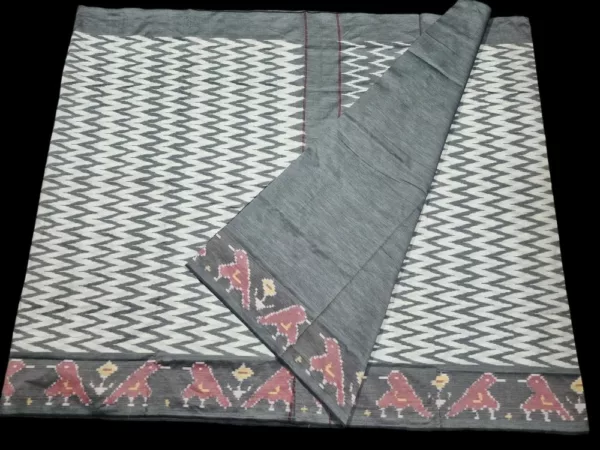 Close-up of a handwoven semi-silk Pochampally saree showing vibrant ikat diamond and temple motifs on a broad border