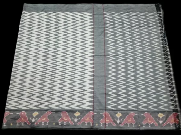 Close-up of a handwoven semi-silk Pochampally saree showing vibrant ikat diamond and temple motifs on a broad border