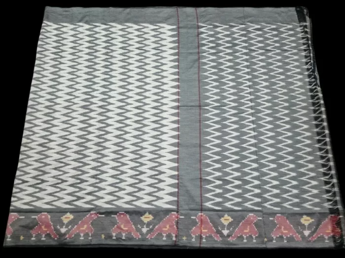 Close-up of a handwoven semi-silk Pochampally saree showing vibrant ikat diamond and temple motifs on a broad border