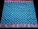 Close-up of a handwoven semi-silk Pochampally saree showing vibrant ikat diamond and temple motifs on a broad border