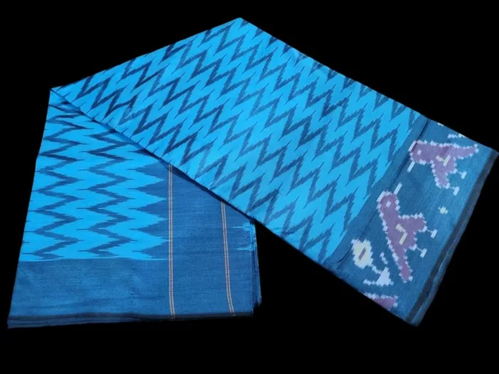 Close-up of a handwoven semi-silk Pochampally saree showing vibrant ikat diamond and temple motifs on a broad border