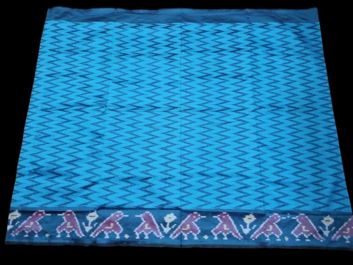 Close-up of a handwoven semi-silk Pochampally saree showing vibrant ikat diamond and temple motifs on a broad border