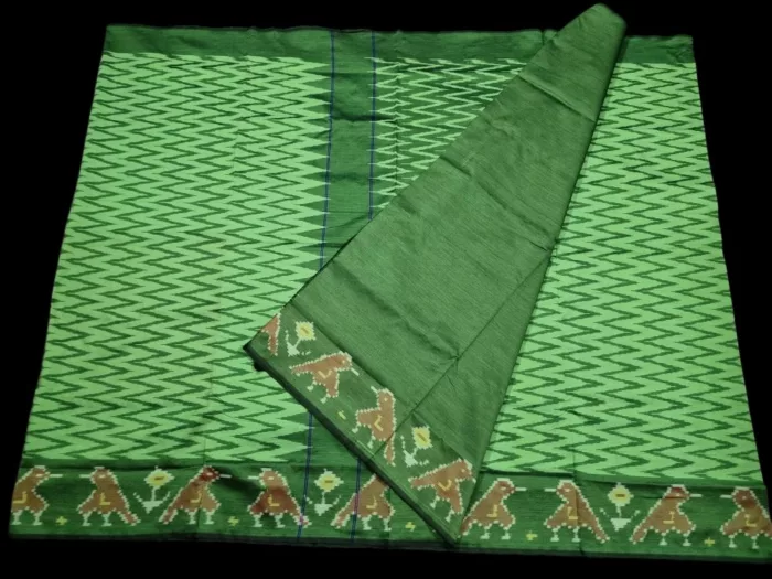 Close-up of a handwoven semi-silk Pochampally saree showing vibrant ikat diamond and temple motifs on a broad border