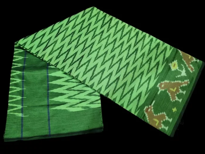 Close-up of a handwoven semi-silk Pochampally saree showing vibrant ikat diamond and temple motifs on a broad border