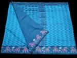 Close-up of a handwoven semi-silk Pochampally saree showing vibrant ikat diamond and temple motifs on a broad border