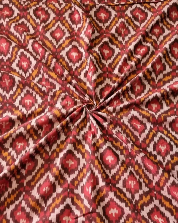 Handwoven Pochampally ikat fabric with red, mustard, and white diamond pattern, traditional geometric design on cotton or cotton-silk textile.
